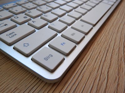 White Computer Keyboard On Brown Wooden Table photo