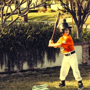 Child Holding Bat During Daytime
