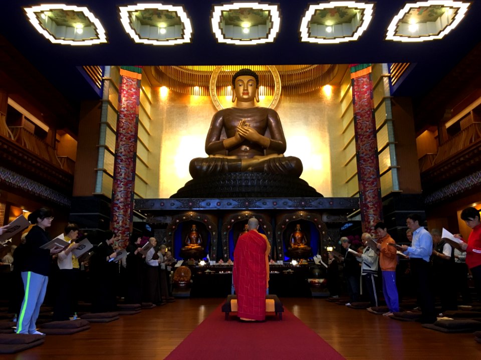 Worshipers Praying To Buddha Statue photo
