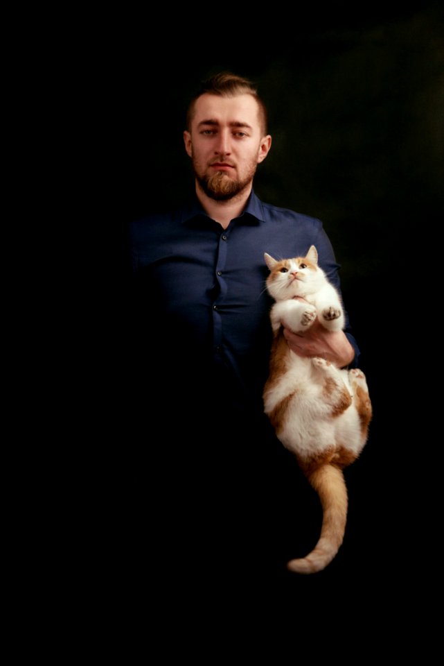 Man In Grey Dress Shirt Holding White And Orange Fur Cat