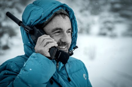 Man In Blue Hoodie Jacket Holding Black Radio Receiver During Snowy Day Time photo