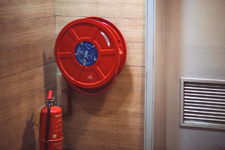 Red Fire Extinguisher Beside Hose Reel Inside The Room photo