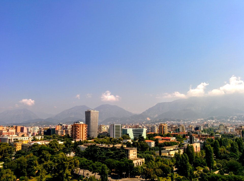 Grey Concrete Building In The Middle Of The City Under Blue Sky