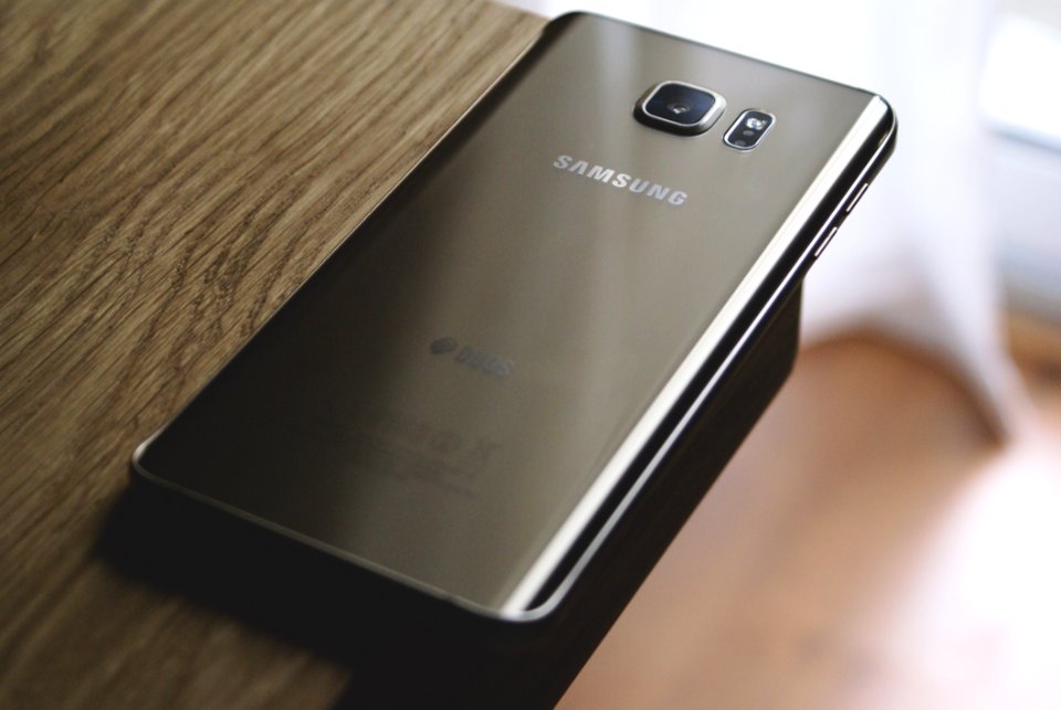 Silver Samsung Galaxy Smartphone On Top Of Brown Wooden Table