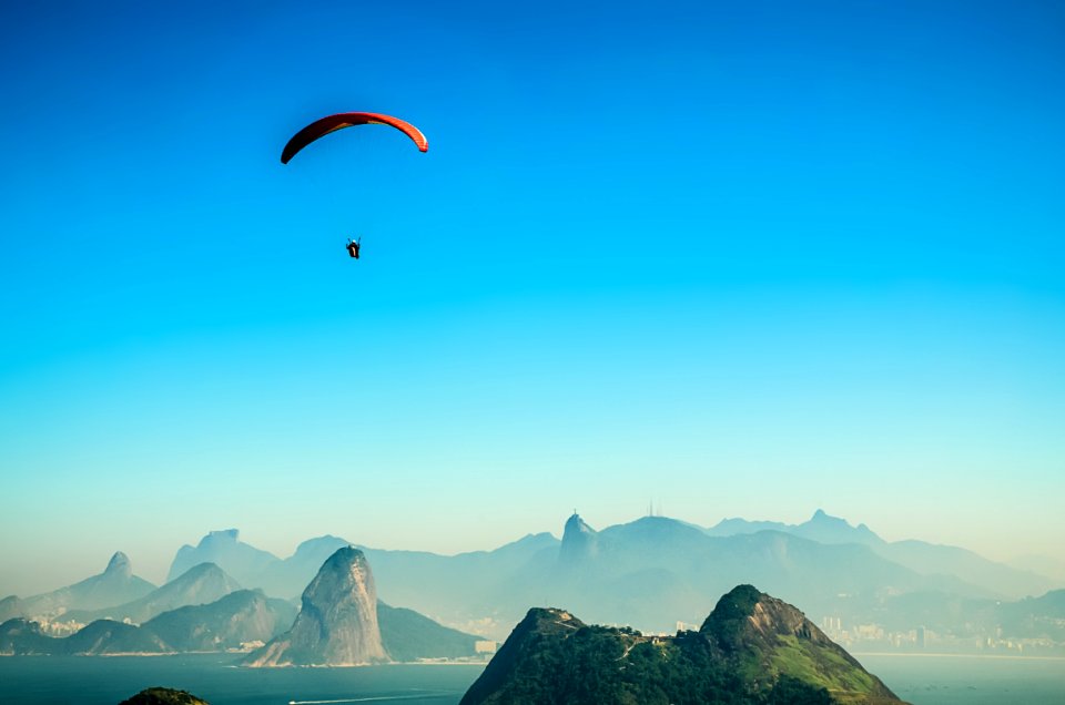 Panorama Photo Of A Person Parachuting Above Volcano Lake During Daytime