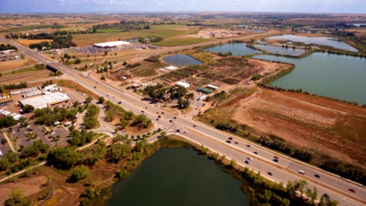 Aerial Photography Of An Open Road With Cars Near City And Lake During Daytime photo