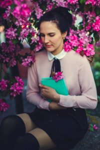 Woman Wearing Beige Long Sleeve Shirt Sitting Beside Purple Petaled Flower photo