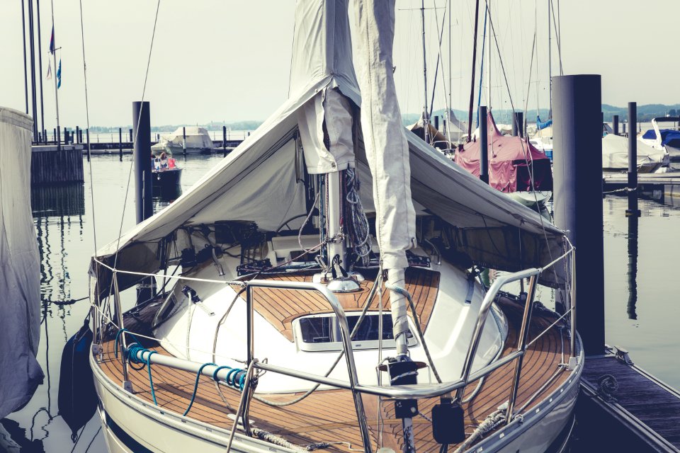 White And Brown Boat On Dock Near Speed Boat