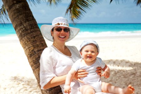 Woman Holding Infant On Beach photo