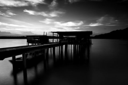 Greyscale Photo Of Dock Near Mountains