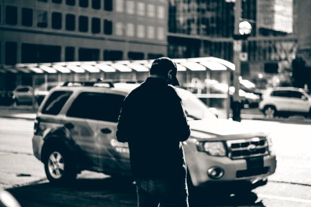 Grayscale Photography Of Man Standing Near Suv During Daytime photo