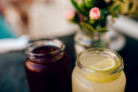 Clear Glass Mason Jar With Lemon Slice On Top Of Cocktail photo