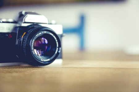 Shallow Focus Photo Of Dslr Camera On Brown Wooden Table photo