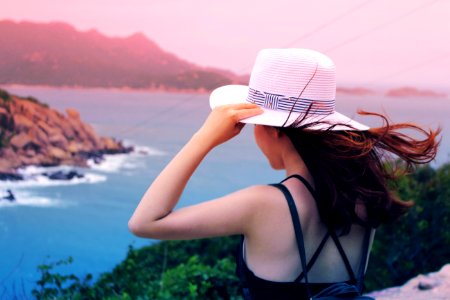 Wman Holding Wricker Shade Hat On Ocean View