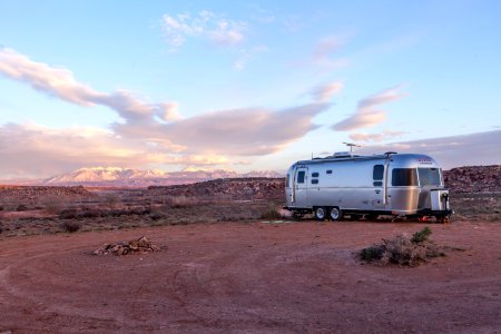 Grey And Black Recreational Vehicle On Ground Under Blue And White Sky
