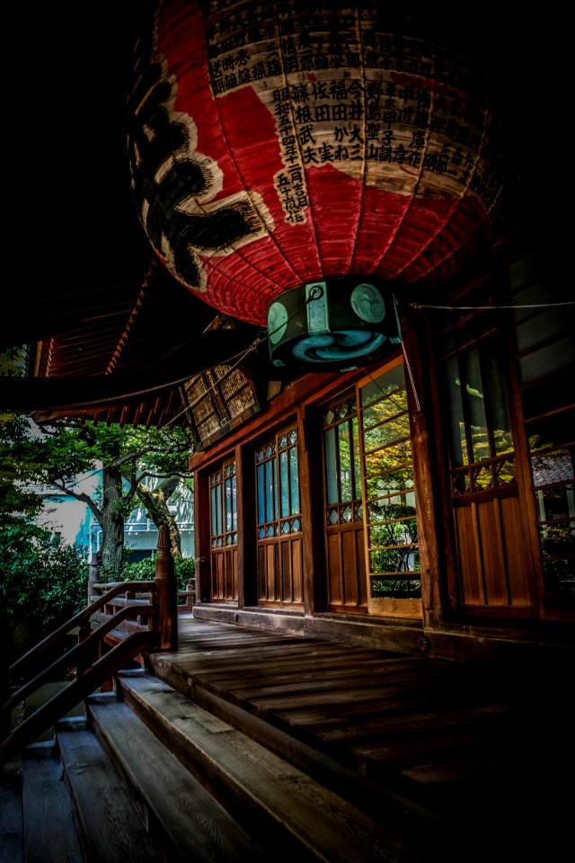 Red Green And Black Floating Lantern With Kanji Text Decoration Above Stairs