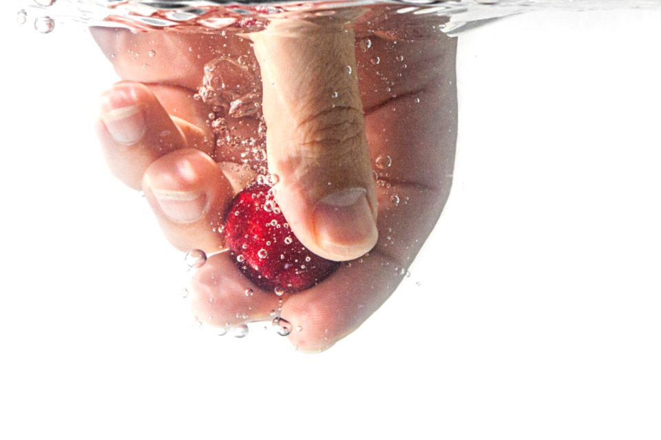 Person Holding Red Ball Underwater