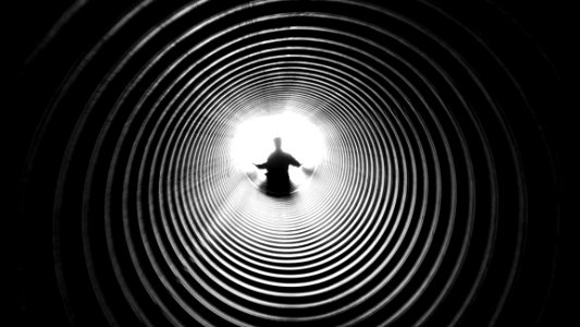 Grayscale Photography Of Person At The End Of Tunnel photo