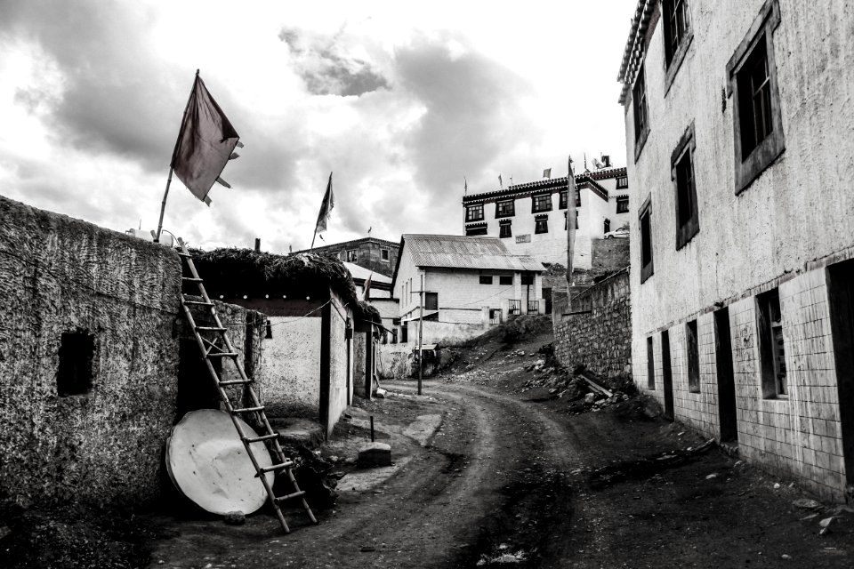 Greyscale Photo Dirt Road Between Buildings