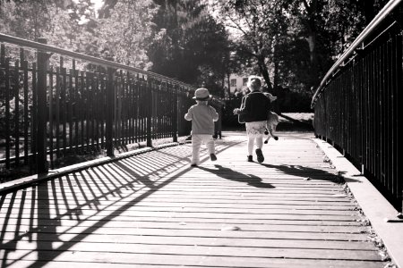 Children Running Together On Wooden Path Way Bridge photo