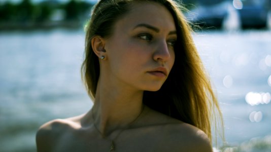 Closeup Photography Of Woman With Gold Necklace Near Body Of Water During Daytime photo