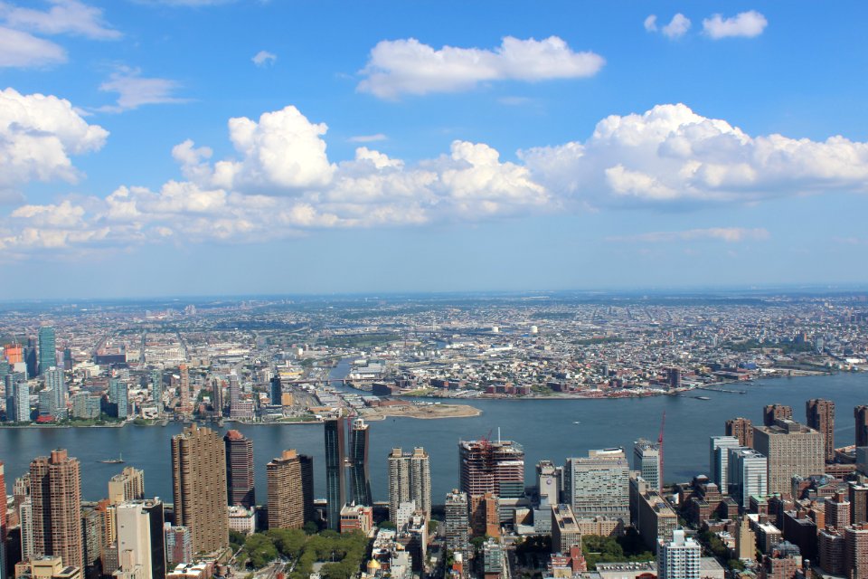 Aerial View Of City Buildings By River Under Blue Cloudy Skies photo