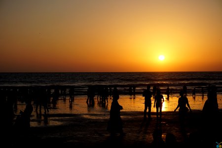 Silhouettes Of People On Beach At Sunset photo
