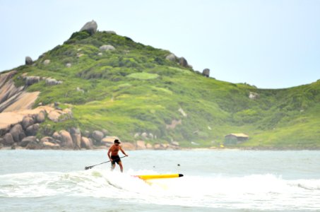 Man In Black Shorts Surfing Under Blue Sky During Daytime photo