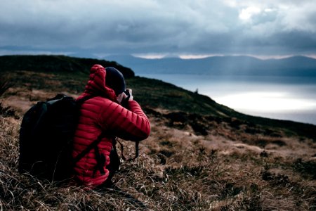 Person In Red Hoodie Taking A Photo Of Wilderness photo