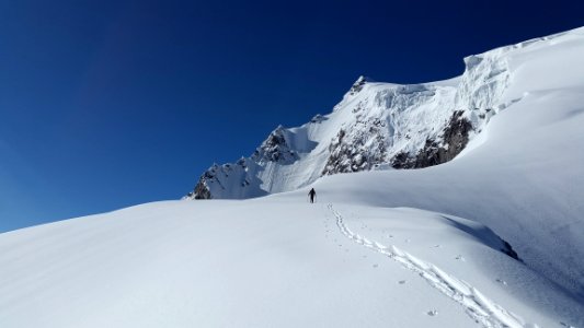 Man Walking In White Mountain Snow During Daytime photo