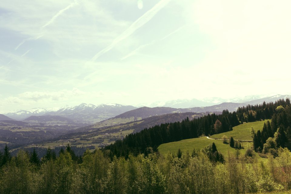 Green Grass Behind Brown Mountain Under White Sky photo