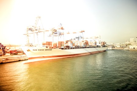 White And Orange Cargo Ship Docking During Daytime photo
