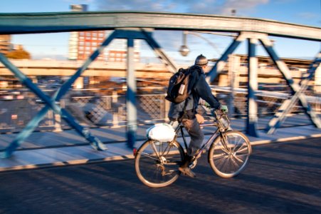 Man In Black Jacket Riding Black Bicycle In Gray Concrete Road In Panning Photography photo