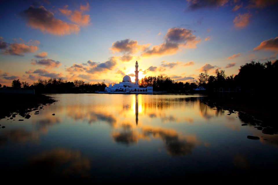 White Building Surrounded By Water And Trees During Golden Hour