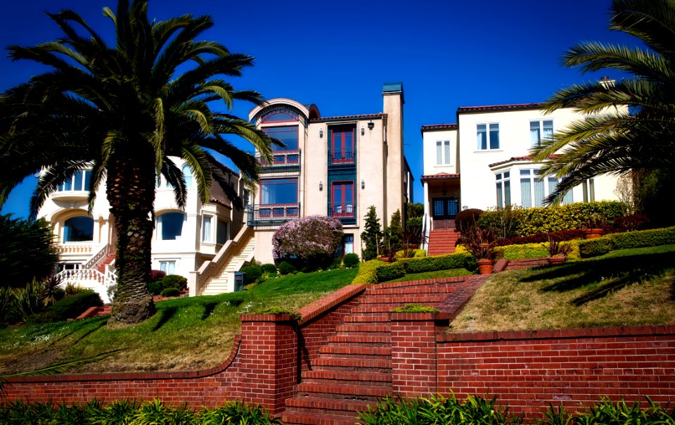 White And Brown Concrete Building Near Green Grass Under Blue Sky During Daytime photo