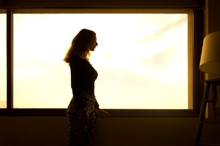 Woman In Black Long Sleeve Shirt And Tribal Leggings Standing By The Window During Daytime photo