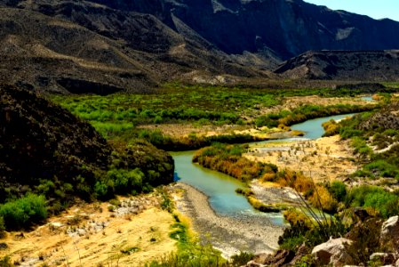 Green Water Between Tress And Mountain During Daytime photo