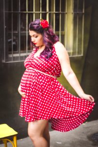 Woman In Red And White Polka Dots Mini Dress Holding Her Stomach