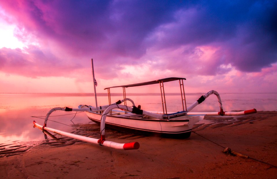 White And Black Motor Boar On Shore At Sunset