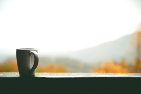 White Mug On Window Over Looking Autumn Trees And Hills In Distance During Daytime