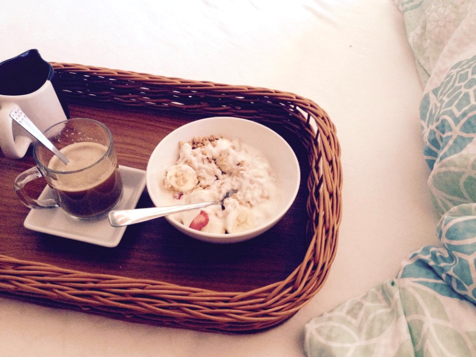 White Round Bowl With Rice And Sliced Bananas Near Clear Glass Mug On Square Ceramic Plate And White And Black Ceramic Mug On Brow photo