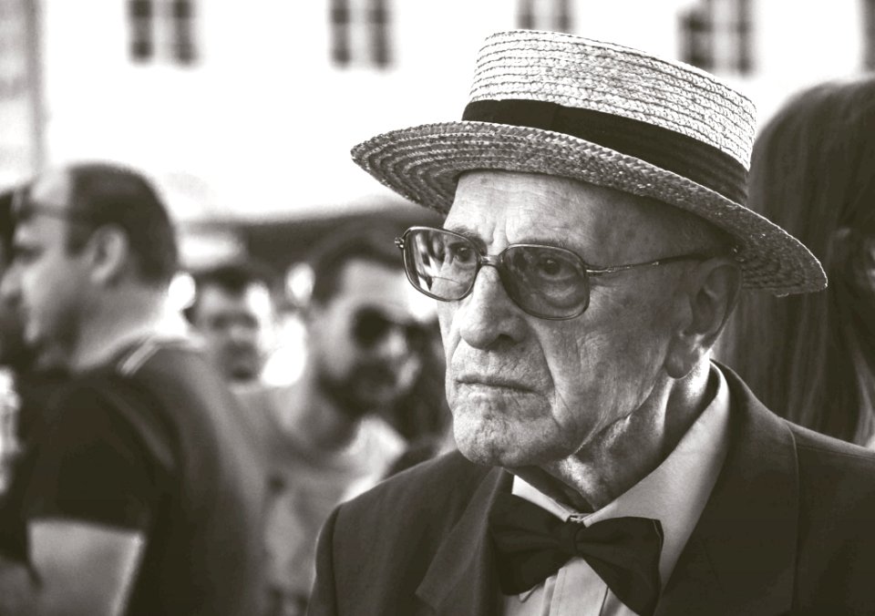 Man In Straw Hat Wearing Bow Tie With People