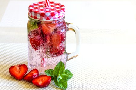 Strawberry Fruits Sliced In Half Near Clear Glass Container photo