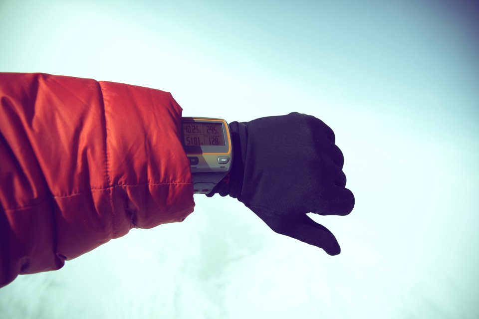 Person In Red Jacket And Black Gloves Wearing Gray Digital Watch