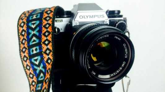 Black And Gray Olympus Dslr Camera White Orange Blue And White Strap photo