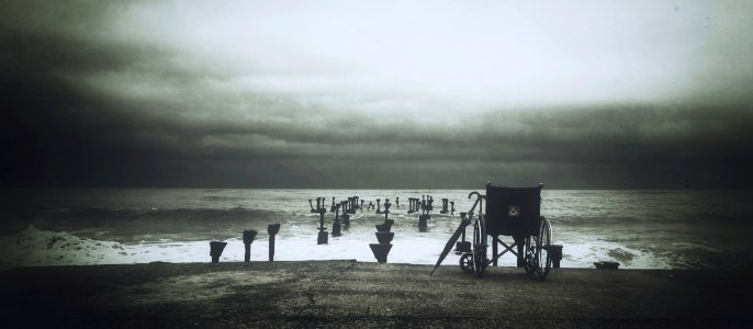 Grey Scale Photograph Of Wheel Chair Near Water Sea