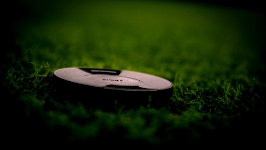 Black Camera Lens Cover On Green Grass