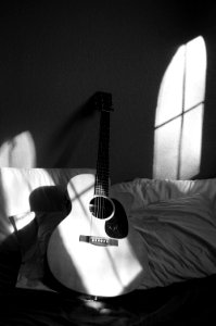White Acoustic Guitar On Grey And White Textile photo