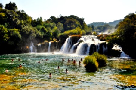 People Swimming Near Waterfall During Daytime photo