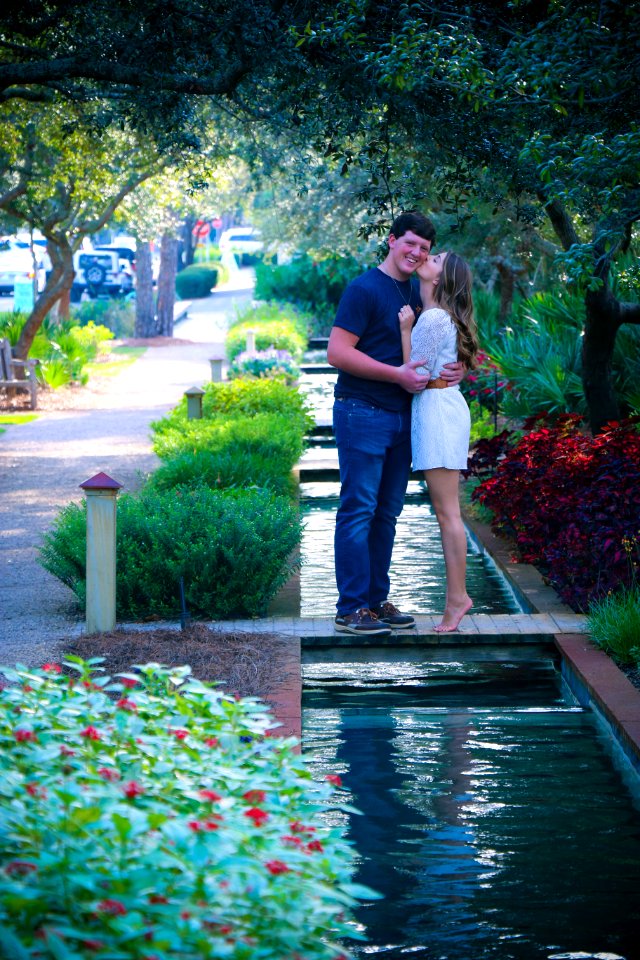 Woman And Man Standing On Bridge Kissing